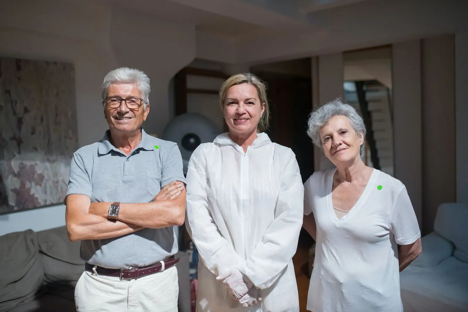 nurse in hazmat with seniors with green stickers on them indicating they are healthy